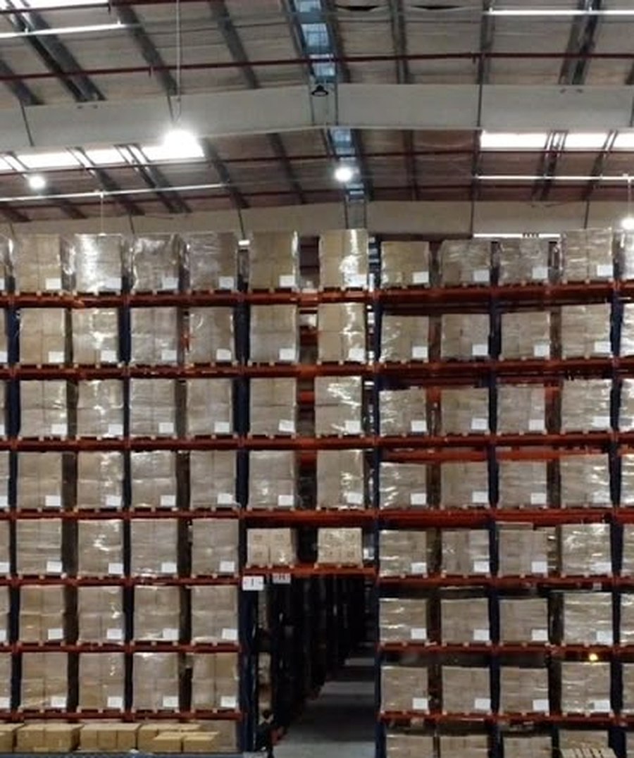 Personal de TAHG preparando pedidos frente a los racks selectivos del depósito